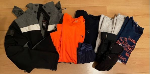 Kleding voor de kledingbank: een jas, t-shirts en handschoenen